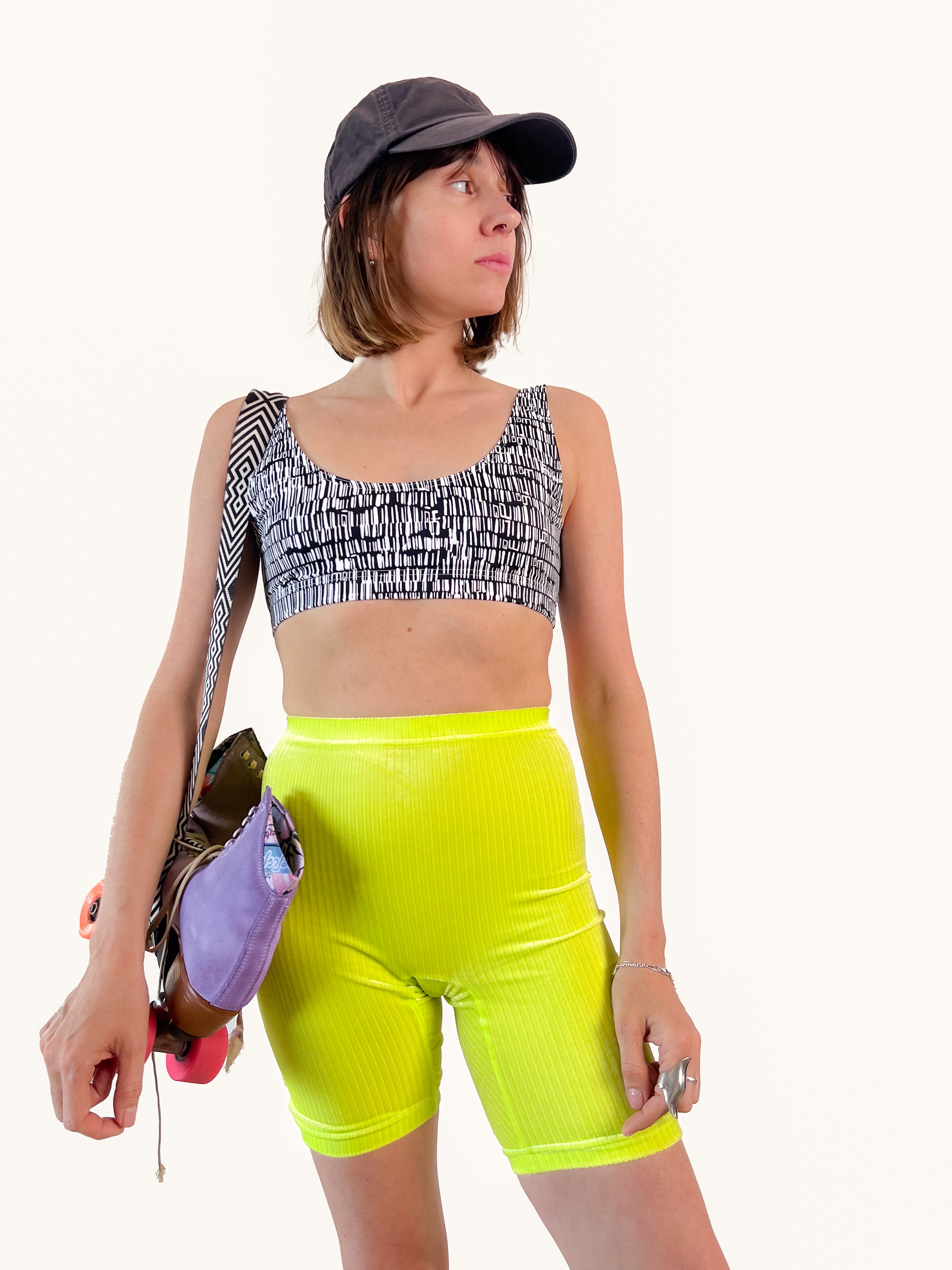 Modèle qui porte le Short cycliste en velours jaune fluo en mode sport avec des roller quad.