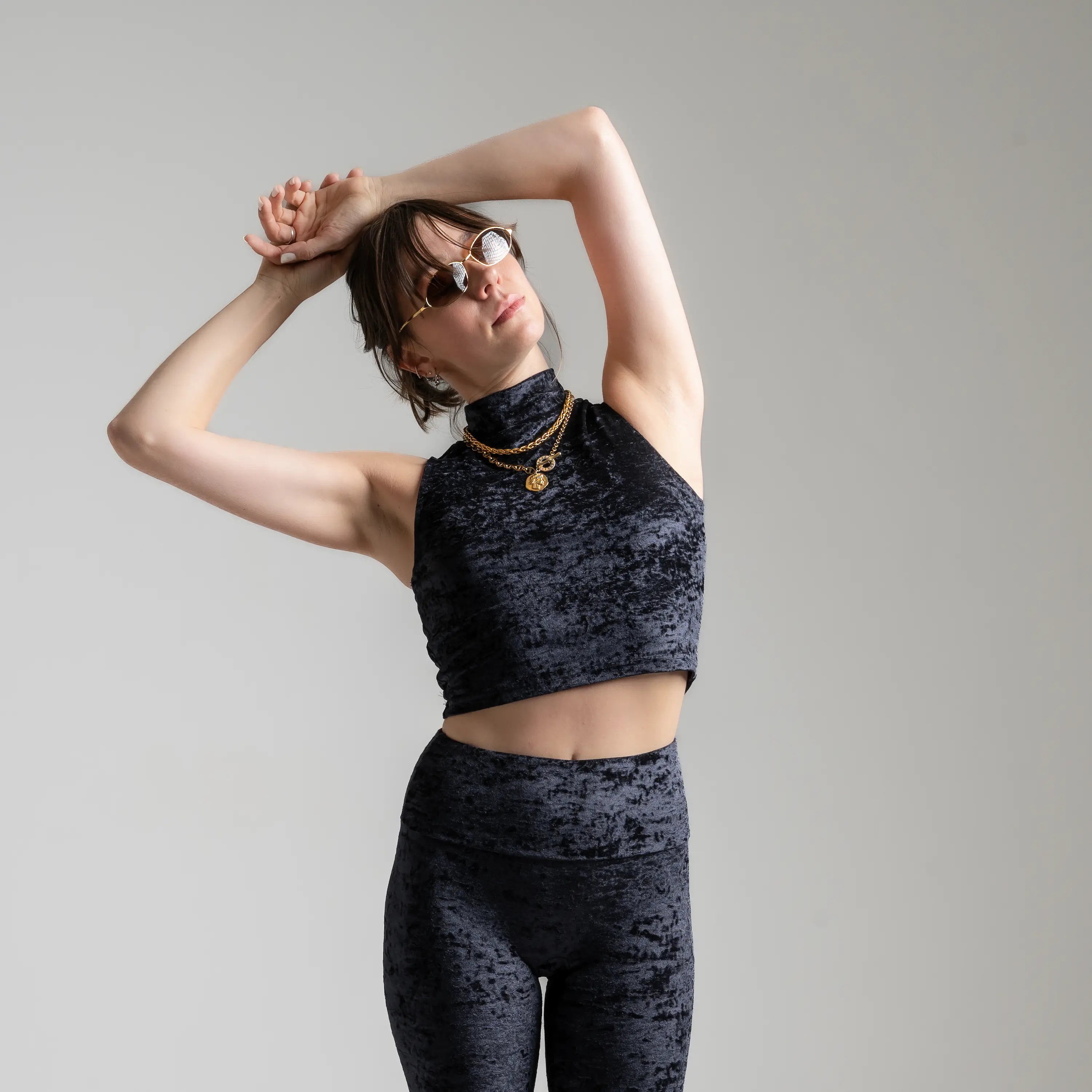 Zoom sur la coupe du top court en velours texturé noir avec bijoux en or supperposés