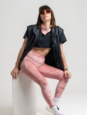 Modèle en legging velours rose stylisé avec une doudoune sans manche noir pour un look sportif.
